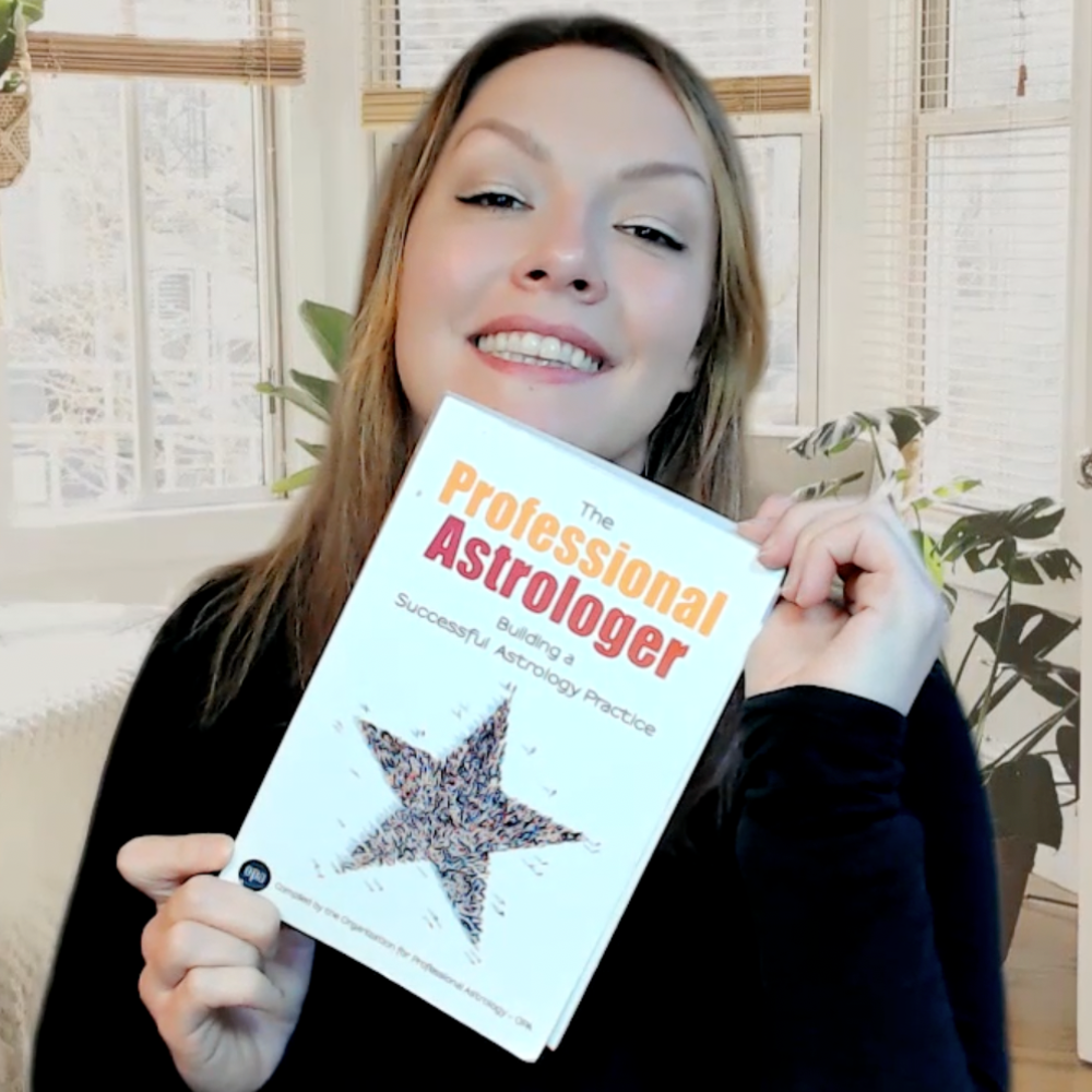 Stefanie James holding a copy of The Professional Astrologer by the OPA
